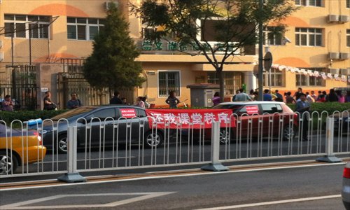Parents protest with a banner saying give me back class order outside Shiji Primary School, Chaoyang district on Thursday. Photo: Courtesy of a parent 