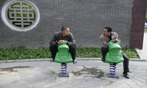 Two men on exercise equipment in Jing'anzhuang, Chaoyang district Tuesday. Photo: Li Hao/GT