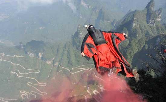 A contestant flies over the mountains during the first wingsuit world flying contest at Tianmen Mountain in Zhangjiajie in Central China's Hunan province, Oct 17, 2012. [Photo by Chen Jianhua/Asianewsphoto] 