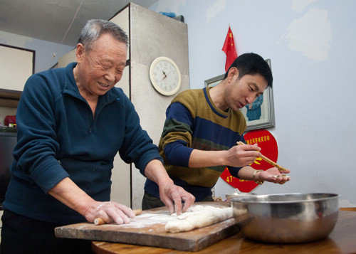 FAMILY LIFE: Gao Wangui, an empty nester in Luyuan Community in Changchun, Jilin Province, makes dumplings with a young volunteer who keeps him company on February 22 (XINHUA)