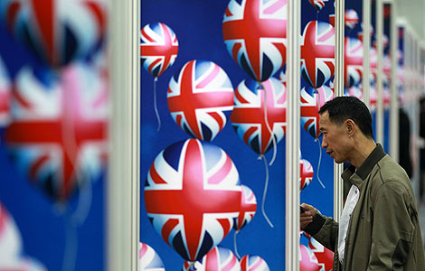 A man looks at information of studying in the UK during the China Education Expo 2012 in Beijing, Oct 20, 2012. [Photo by Cui Meng/Asianewsphoto]