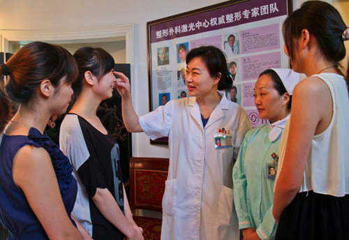 A plastic surgeon talks with high school students who are considering plastic surgery at the People��s Liberation Army No 455 Hospital in Shanghai in August. [Photo/China Daily]