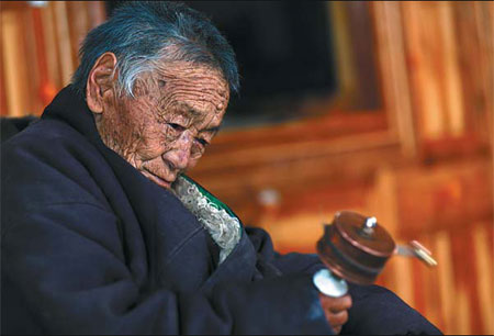 At 106 years young, Begar enjoys a moment of serenity with a prayer wheel at her home in Baqen county, the Tibet autonomous region. She credits her longevity to a diet of vegetables and fruit. Cui Meng / China Daily