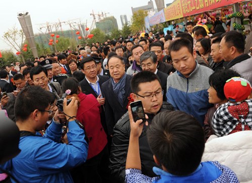 Mo Yan is warmly welcomed by fans at the Red Sorghum Cultural Festival in Gaomi city, Shandong province, on Oct 29, 2012. The third Red Sorghum Cultural Festival became a much bigger event this year after Mo Yan won the Nobel Prize. Mo, author of the novel Red Sorghum, said he hopes other Chinese writers and artists can receive more attention now.[Photo/Asianewsphoto]