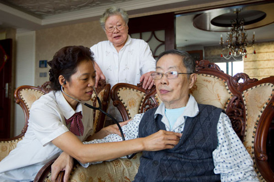 Chen Hua (left), a community doctor, gives an 84-year-old man a routine examination at the man's home in the Zhoujiaqiao community of Shanghai on Oct 12. Gao Erqiang / China Daily