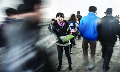 A woman hands out flyers advertising a day trip to tourists at the entrance of Tiananmen Thursday.
