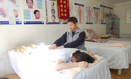Qigong practitioner Liu Sujiang tends to a patient at his clinic in Shuangjing, Chaoyang district. Photo: Jonny Clement Brown/GT 