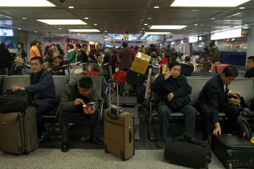 Passengers are stranded at the Beijing Capital International Airport amid a snowstorm on Sunday. Feng Yongbin / China Daily