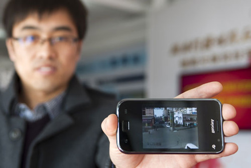A man displays surveillance camera footage he received on his smartphone in Karamay, Xinjiang. Karamay has gone to great lengths to build a smart city to better serve local people. WANG FEI / XINHUA