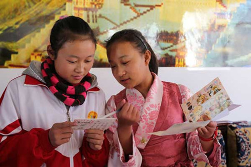 Tenzin Yangkyi (right) and Huang Yang get to know each other in a pairing program at Lhasa No 2 Middle School in the Tibet autonomous region. [Da Qiong/China Daily]
