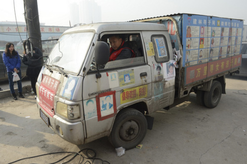 A parent drives a car decorated by photos of mission children in Taiyuan, North China's Shanxi province on Nov 18, 2012. [Photo/Asianewsphoto]