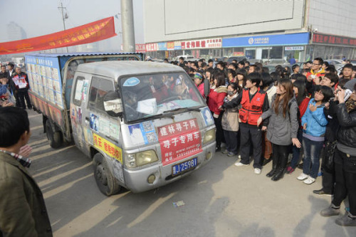 Volunteers help the car cross a road in Taiyuan, North China's Shanxi province on Nov 18, 2012. [Photo/Asianewsphoto]
