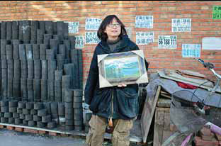 Xu Lili displays her oil paintings outside the room she rents in the village. 
