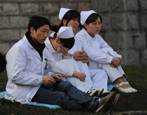 Medical staff wait outside the Xiangshui Coal Mine in Guizhou province on Sunday. Rescuers continued to search for one trapped miner after 22 people were killed in an accident on Saturday. [Photo/Xinhua] 