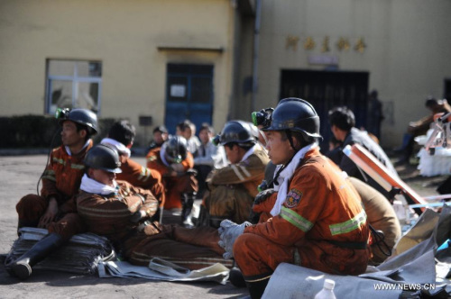 Rescuers take a rest before entering the shaft to continue rescue work at the Xiangshui Coal Mine in Panxian County of Liupanshui City, southwest China's Guizhou Province, Nov. 25, 2012. Nineteen miners were confirmed dead, and four others remain trapped 