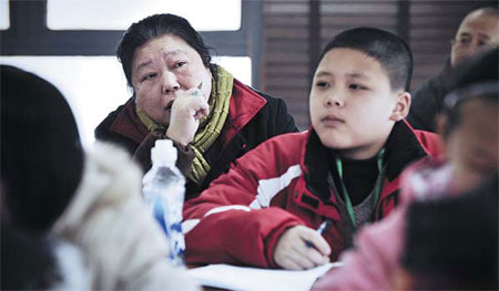 Wang Fengshu watches with concern etched on her face as her grandson Tang Haolong figures it out at a math olympiad class in Wuhan, Hubei province. Provided to China Daily.  
