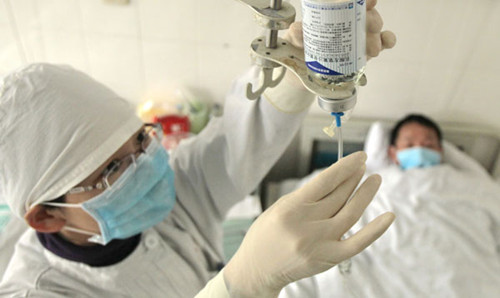 A nurse adjusts the medication of an AIDS patient at a hospital in Nantong, Jiangsu province, on Thursday. [Xu Congjun / For China Daily]