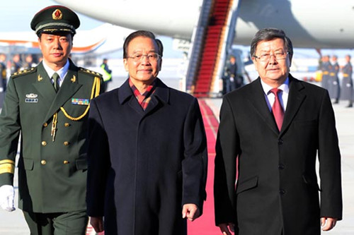 Premier Wen Jiabao arrives in Bishkek on Tuesday to attend the 11th prime ministers' meeting of the Shanghai Cooperation Organization and pay an official visit to Kyrgyzstan. Kyrgyz Prime Minister Jantoro Satybaldiev welcomed Wen at the airport. [Photo/Xinhua]