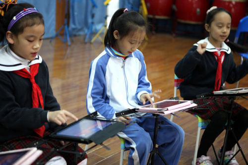 Students play simulated instruments on iPads, including Chinese instruments such as the guzheng and pipa, and Western ones such as the piano and violin, at the Lilin Primary School, affiliated with Shenzhen Nanshan Shiyan School, in Guangdong province on Monday. PHOTO BY ZHAO YANXIONG / FOR CHINA DAILY