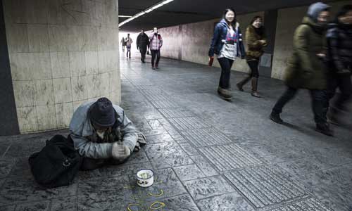 A homeless man begs for money in an underpass near Xizhimen Bridge, Xicheng district Thursday. Photo: Li Hao/GT 