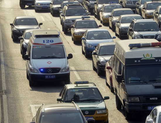 An ambulance is seen in a traffic jam during the morning rush hour in Beijing on Monday. [Photo by Yang Yi / FOR CHINA DAILY]