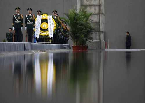 Soldiers carry a wreath during a ceremony marking the 75th anniversary of the Nanjing Massacre on Thursday in Nanjing, capital of Jiangsu province. [Photo/Agencies]