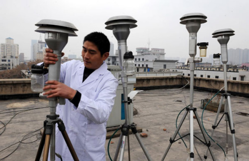 A worker with the Zhengzhou Environmental Protection Bureau in Zhengzhou, Henan province adjusts the equipment used to monitor the city's level of PM2.5 on Dec 18, 2012. [Photo/Xinhua]