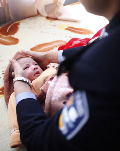 A baby is resued by police from a child trafficking ring in Quanzhou, Fujian province on Dec 19, 2012. [Photo/Xinhua]