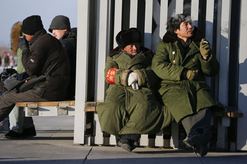 Smokers take a break at the Olympic Green in Beijing on Sunday. KUANG LINHUA / CHINA DAILY