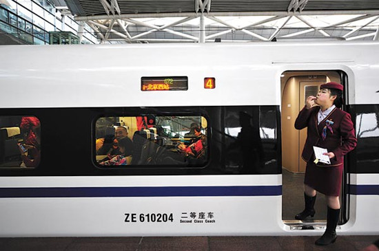 In a throwback to another era, an attendant whistles for passengers to board the high-speed train for Beijing at Guangzhou South Railway Station on Wednesday. The train was set for its maiden journey on the world��s longest high-speed track. Ke Xiaojun / 