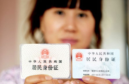 A Chinese woman shows a first-generation ID card, left, and a second-generation card. [Photo: CRIENGLISH.com/cqnews.net]  