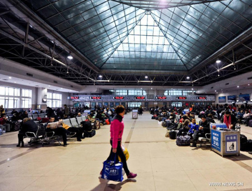 A passenger walks across a waiting room of Harbin Railway Station in Harbin, capital of northeast China's Heilongjiang Province, Jan. 1, 2013. Harbin's railway system has witnessed a travel peak around the 2013 New Year's Day, a national holiday. In the meantime, the number of passengers departing from the Harbin Railway Station is expected to exceed 500,000 during the 3-day holiday. (Xinhua File Photo)