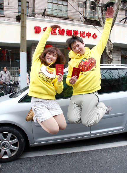 Shen Haiqing (left) and Yao Zhihua celebrates after they got married yesterday at Jing'an Marriage Registration Center.