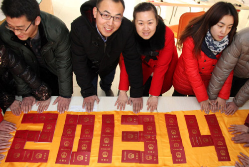 Newlyweds pose for photos with their marriage certificates spelling out the date of Jan 4, 2013, in Zaozhuang city, East China's Shandong province. Chinese couples consider Jan 4, 2013, as the best day in 10,000 years to tie the knot, because the date sou