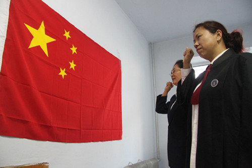 Two new lawyers take an oath in Heihe, Heilongjiang province, on Nov 1 before starting their careers. [Photo/China Daily]