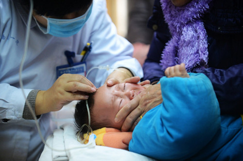 Parents and grandparents take their children to the No 1 People's Hospital in Yangzhou, Jiangsu province, for treatment on Monday. Meng Delong / for China Daily