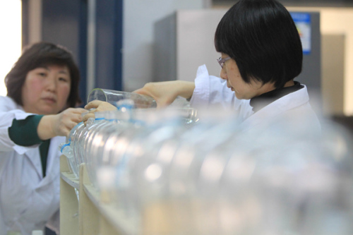 Technicians test the water quality at Beijing No 9 Water Factory on Monday. [Photo/China Daily]