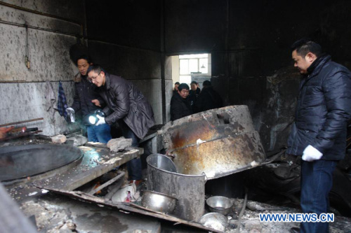 People check the canteen after an explosion at Kuixiang High School in Yiliang County, Zhaotong City, southwest China's Yunnan Province, Jan. 8, 2013. One person died and four others were injured in the explosion at the canteen, authorities said Tuesday. The cause of the accident is under investigation. (Xinhua/Long Jiao)