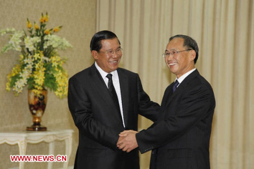 Cambodian Prime Minister Hun Sen (L) shakes hands with Zhang Mingpei, director-general of Department of Agriculture of China's Guangxi Zhuang Autonomous Region, at the Peace Palace in Phnom Penh, Cambodia, Jan. 8, 2013. China's Guangxi Zhuang Autonomous Region on Tuesday donated 100 tons of milled rice to Cambodia as humanitarian aid. (Xinhua/Phearum)