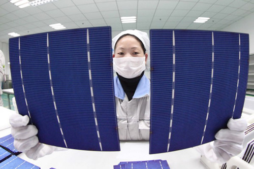 A worker checks solar panels for export to Europe at a factory in Ganyu, Jiangsu province. Last year, the United States and the European Union began to impose punitive anti-dumping tariffs on Chinese solar panels. [Photo / For China Daily]