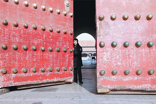A staff member closes the gate of the Palace Museum in Beijing on Monday morning. It was the first day of the museum's trial to close on Monday afternoons during the off-season, from Jan 1 to March 31. [Photo/China Daily]