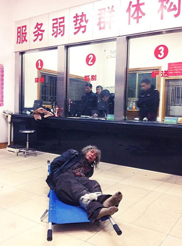 Li Guting, a 51-year-old vagrant, lies on a stretcher with his legs tied tightly together at Changsha Homeless Shelter in Changsha, capital of Hunan province, on Monday night. Li Feng, director of the shelter's general office, said the man was mentally disabled and police had handcuffed him in case he was violent. [Photo/China Daily] 