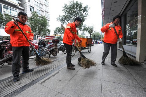 Two newly-recruited civil servants, Wu Kangjian (middle) and Liu Yu work together with a cleaner, Dong Yilong, to clean a street in Wuyi county in East Chinas Zhejiang province, Jan 8, 2013. [Photo/Xinhua]