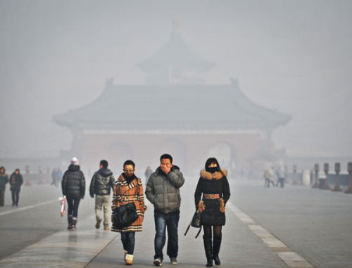 Tourists wearing facemasks walk by the Temple of Heaven in Beijing, as Saturday's PM 2.5 air quality index reached around 470-490. [Photo/Xinhua]