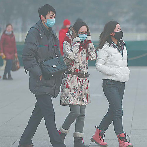 Visitors to Tiananmen Square wearing face masks as protection against the heavy pollution. [Feng Yongbin/China Daily]