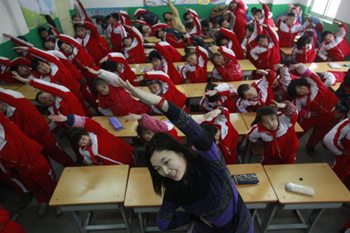 Students exercise indoors at a primary school in Jinan, Shandong province, on Monday. The heavy smog that recently descended on the city forced school authorities to move exercises that are usually conducted outdoors, inside. Zheng Tao / for China Daily