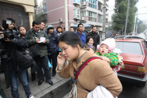 Wang Min, wife of Liao Deying, one of the victims of serial killer Zhou Kehua, waits for the trial result outside a court in Chongqing on Tuesday. [Fan Fan/For China Daily]