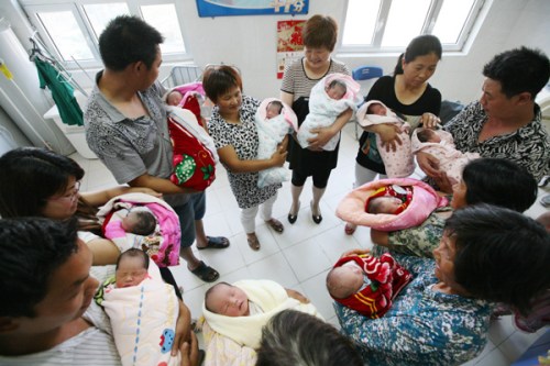 Parents and family members hold five sets of twins who were born on the same day at No 1 People's Hospital of Xiangyang, Hubei province, in May. [Gong Bo/For China Daily]