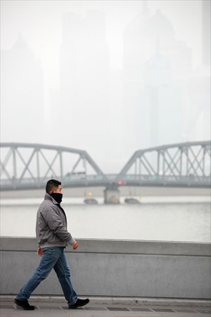 A man walks on the Bund Wednesday against the backdrop of a barely visible Pudong skyline. Photo: Cai Xianmin/GT 