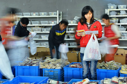 Employees work in the distribution center of a Chinese e-commerce company sending out goods purchased during the shopping spree on Singles Day, Nov 11, 2012. LONG WEI / FOR CHINA DAILY